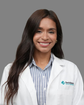 Portrait of a smiling female healthcare professional in a white coat.
