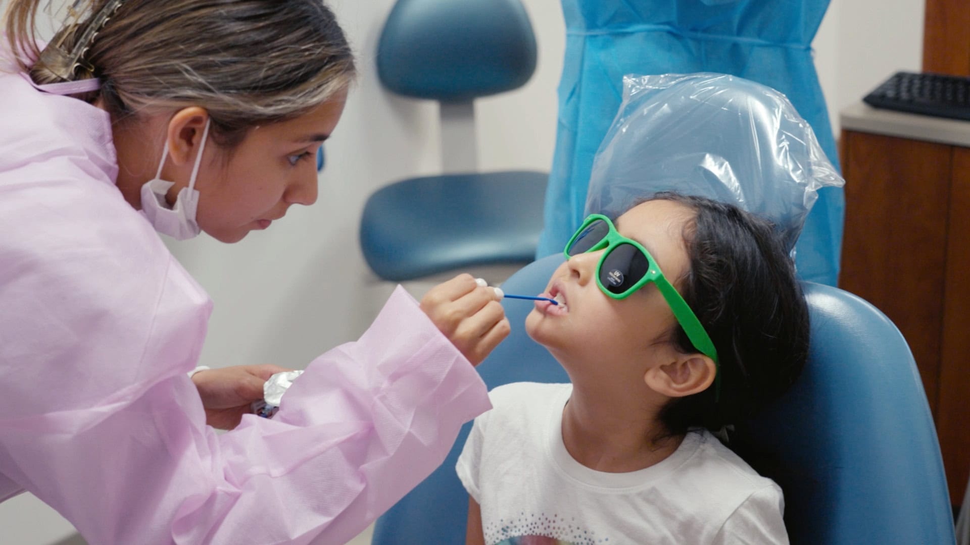Child receiving dental checkup during Give Kids a Smile Day event.