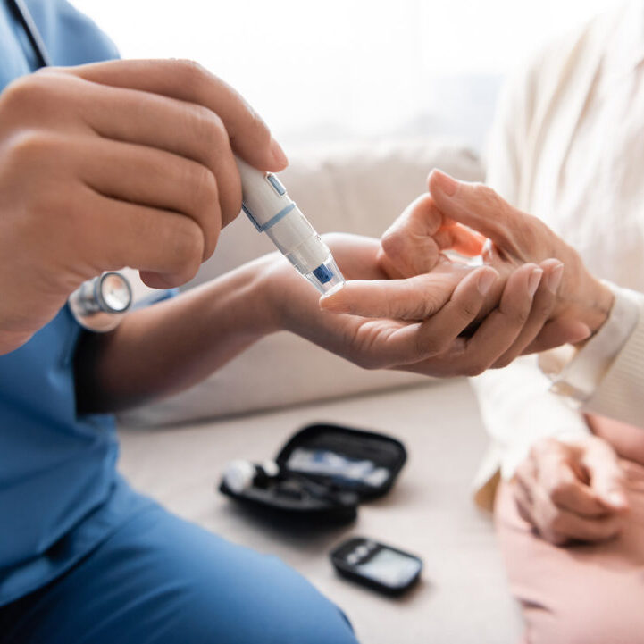 cropped view of multiracial nurse taking blood sample of senior woman with lancet pen. cropped view of multiracial nurse taking blood sample of senior woman with lancet pen,stock image