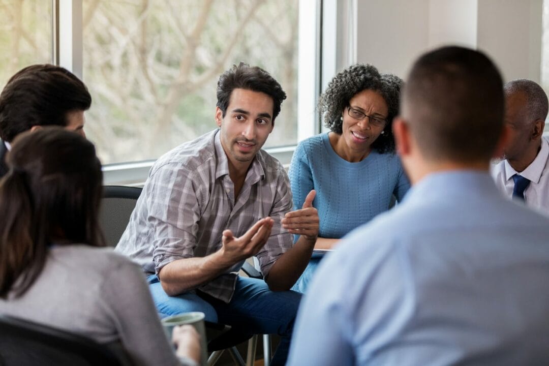 A group of people sitting around a table talking.